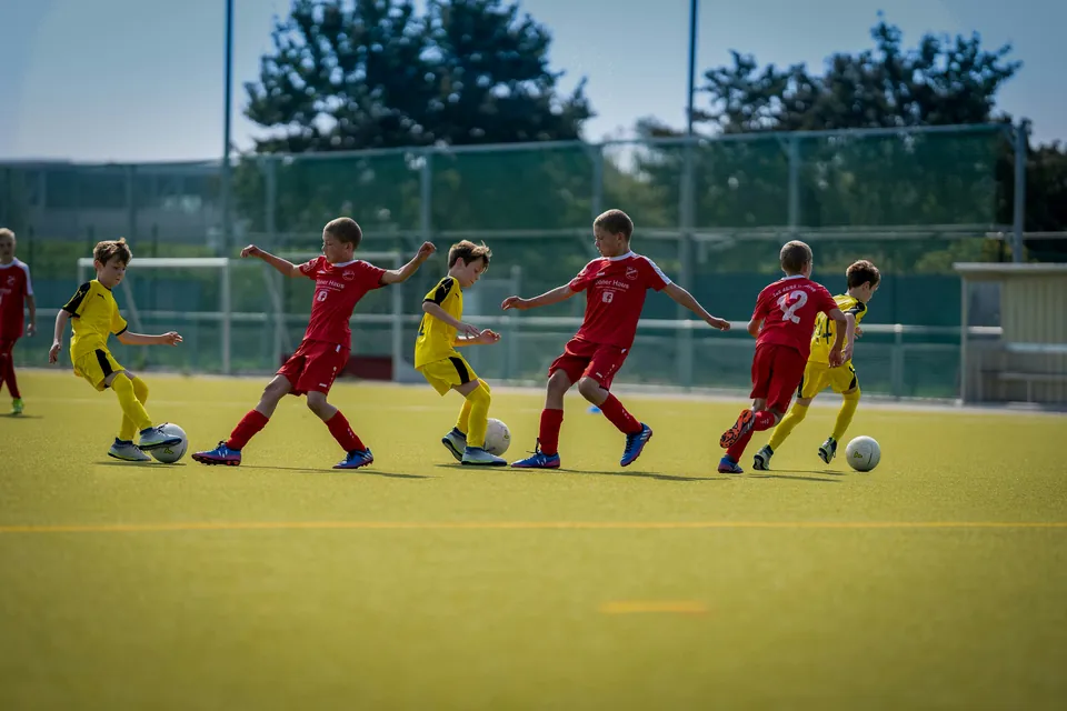 Kinder im Fußballspiel auf dem Kunstrasenplatz